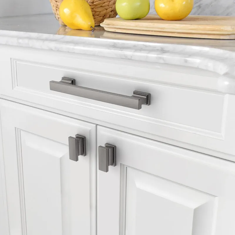 Sleek nickel pulls complement crisp white shaker cabinet doors, featuring a luxurious marble countertop and elegant kitchen design details.