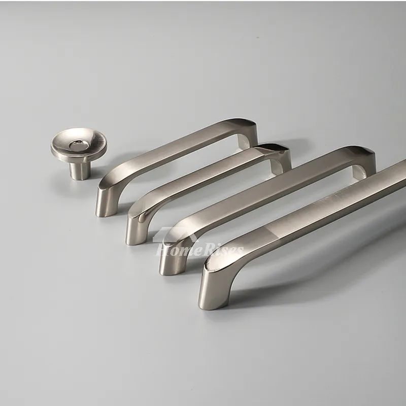 A sleek collection of brushed nickel cabinet pulls and a matching knob, showcasing contemporary hardware designs on a clean, minimalist gray surface.