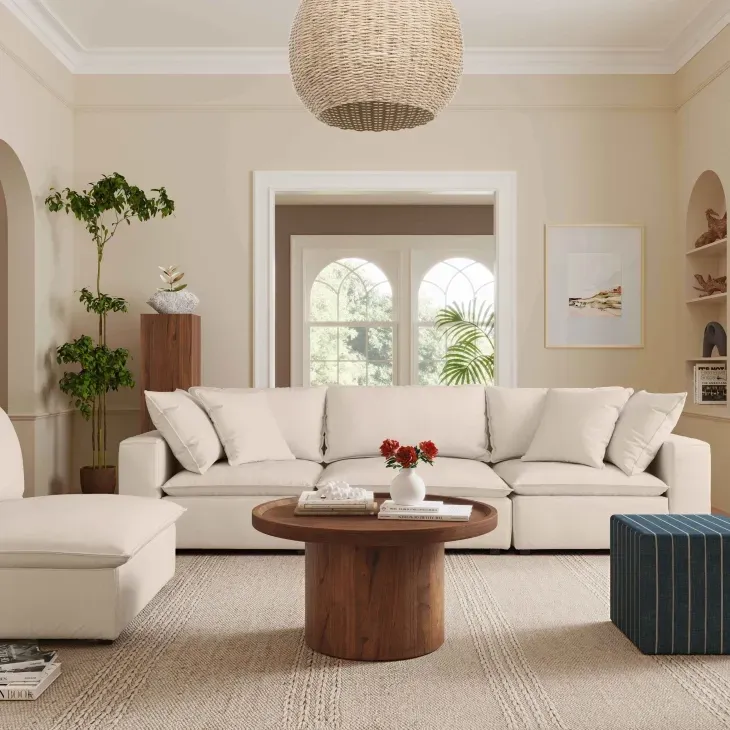 A bright modern living room features an inviting natural fiber upholstered sofa, woven jute rug, and a rustic wood coffee table, creating a serene, eco-friendly interior design.