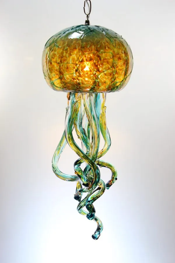 This unique jellyfish chandelier showcases textured amber and teal blown glass, illuminating a dynamic and ethereal statement light fixture.