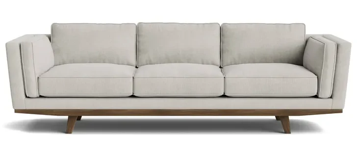 This modern sofa features textured cream natural fiber upholstery on a sleek wooden base, offering a stylish and eco-friendly furniture design.