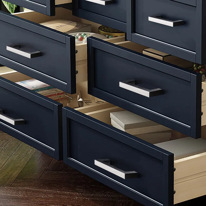 Navy shaker kitchen cabinet doors with sophisticated nickel pulls reveal light wood drawer interiors, showcasing sleek interior design with stylish hardware.